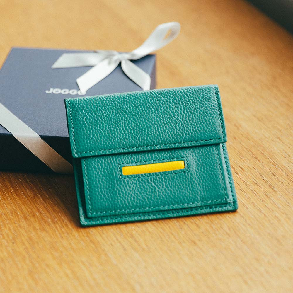 ルーフミニウォレット - ＪＯＧＧＯの特徴のアイコンポケット。差し色にしてアクセントにしたり、本体と同じ色にして一体感を出したりとカスタマイズ次第で雰囲気が変わります。ステッチも革の色ごとに変え、革職人による繊細なハンドメイド仕上げとなっています。プレゼントにふさわしい、細部へのこだわりを徹底しています。