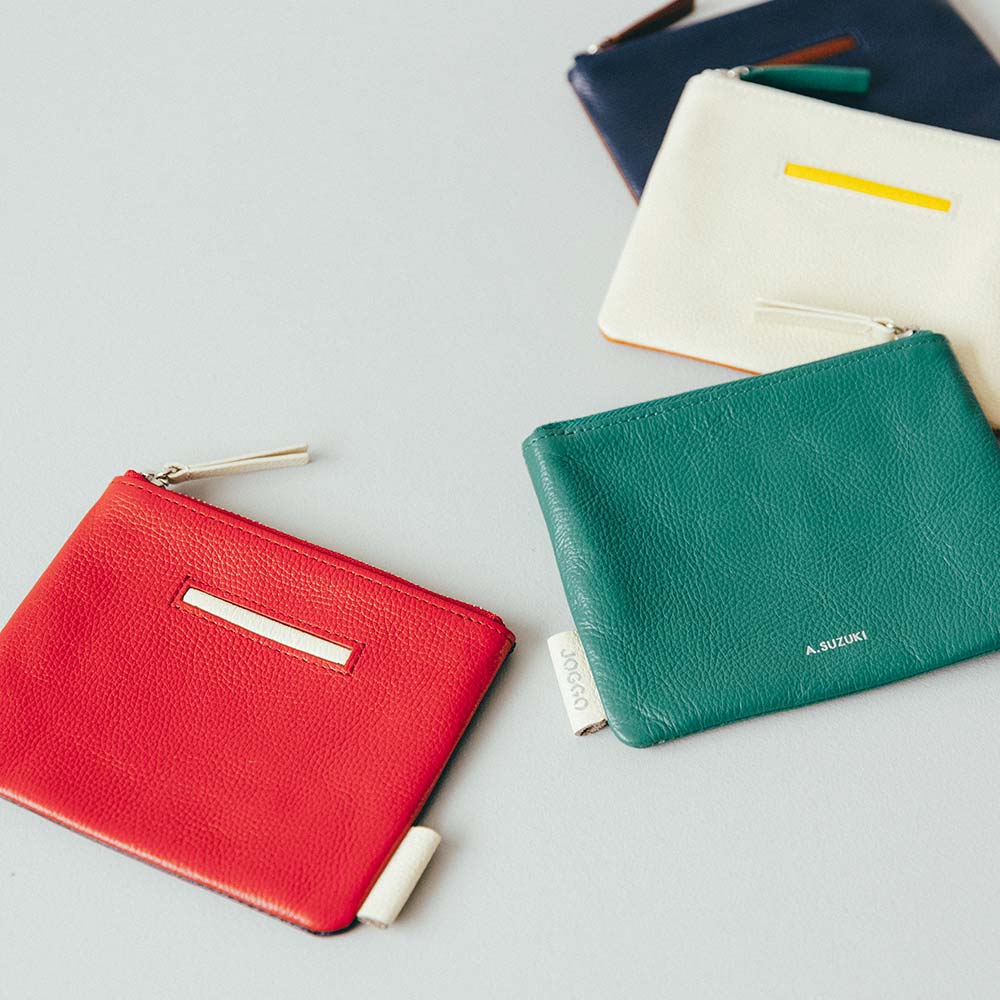 フラットレザーポーチＳ - 全部で4か所のカラーカスタマイズが可能です。アイコンポケットやタグなどアクセントのあるデザインで、シンプルながらもおしゃれさを演出できます。ステッチも革の色ごとに変え、革職人による繊細なハンドメイド仕上げとなっています。プレゼントにふさわしい、細部へのこだわりを徹底しています。