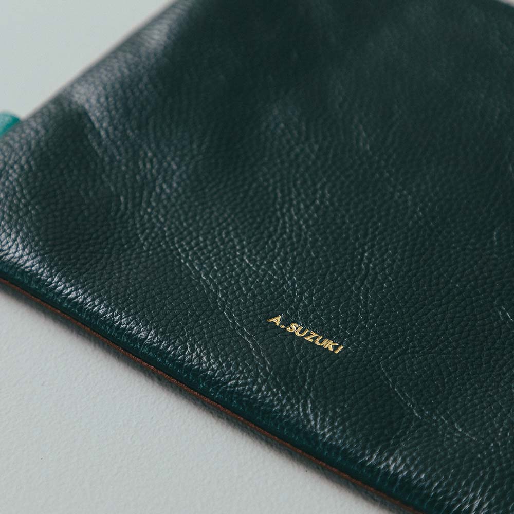 フラットレザーポーチＭ - 名入れは背面の下部に入ります。ワンポイントデザインにもなるので、名前以外にもイニシャルやラッキーナンバーを入れるのもおすすめです。