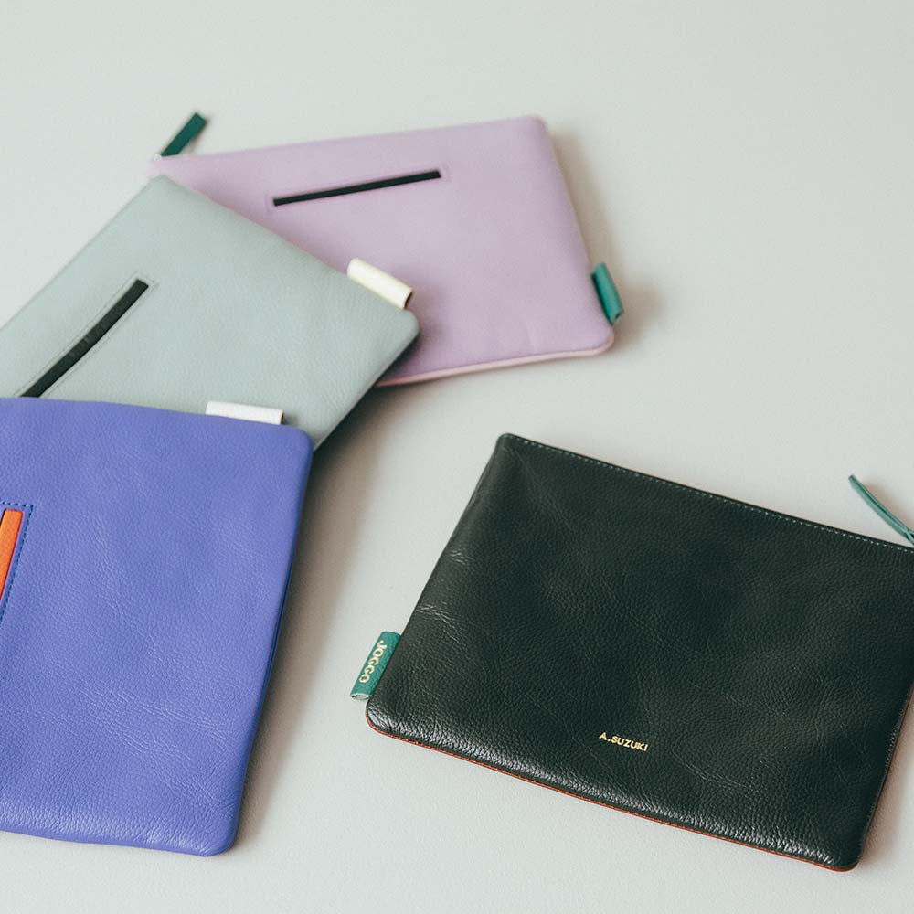 フラットレザーポーチＭ - 全部で4か所のカラーカスタマイズが可能です。アイコンポケットやタグなどアクセントのあるデザインで、シンプルながらもおしゃれさを演出できます。ステッチも革の色ごとに変え、革職人による繊細なハンドメイド仕上げとなっています。プレゼントにふさわしい、細部へのこだわりを徹底しています。