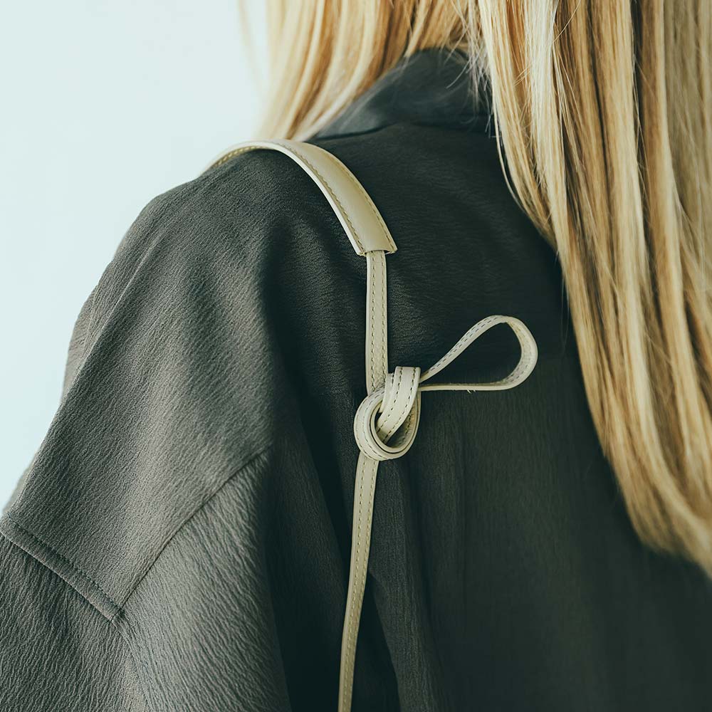 レザー巾着バッグ - 人気の巾着の形はそのままに、ショルダーストラップを改善しました。肩の負担を軽減するために少し太くしました。また、自分で結ぶことでより自由に長さを調整できる様に改良しました。