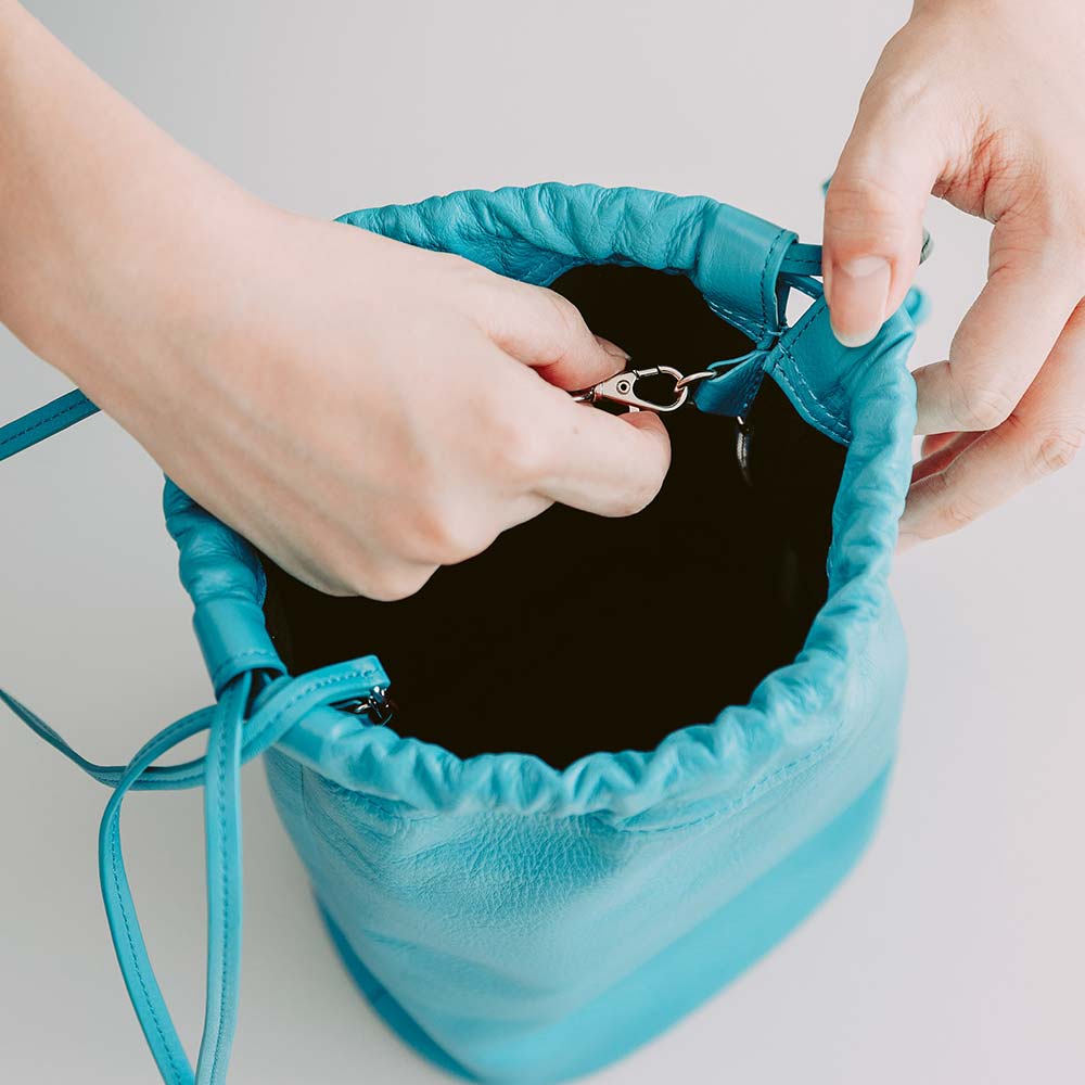 レザー巾着バッグ - 付属するストラップを内側の金具に取り付ければ、ショルダーバッグとしても使えます。そのまま肩にかけたり、斜めにかけたりシーンに合わせて持ち方を変えることができます。