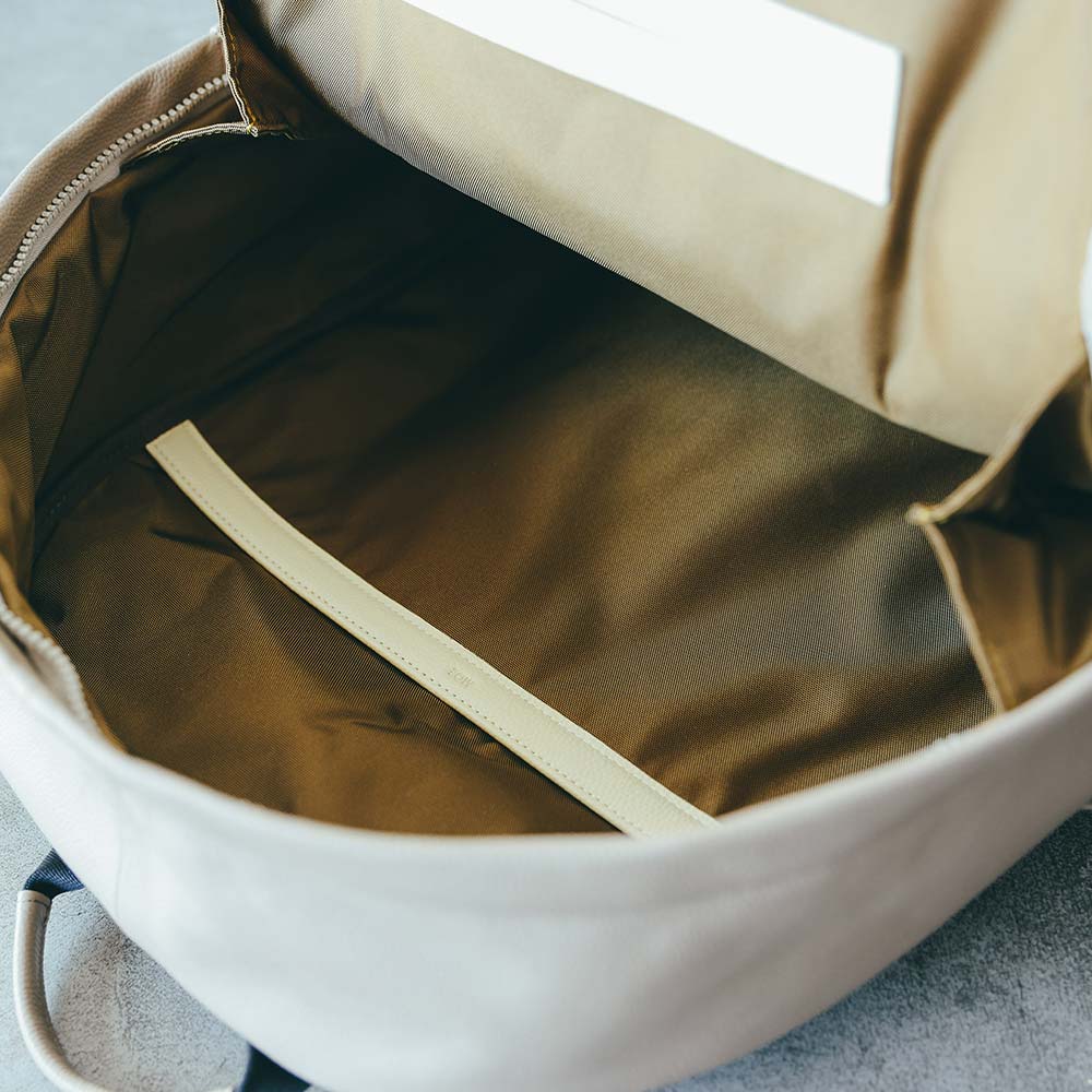 ラウンドレザーバックパック - 裏地は撥水加工が施され、耐久性に優れた高密度ナイロン素材のCORDURA®ECOを使用しています。CORDURA®ECOはリサイクルナイロン100％で、使用感だけでなく環境へも配慮しています。