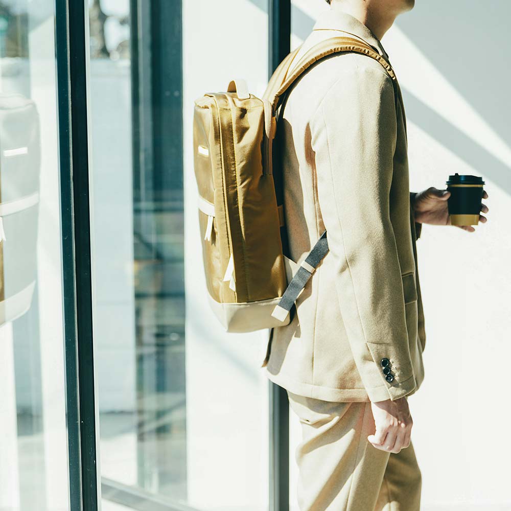 CORDURA® ECO ビジネスバックパック - モデル身長：175cm / 使用カラー：コヨーテ（ナイロン）・グレージュ（レザー）・アイボリーホワイト（レザー）