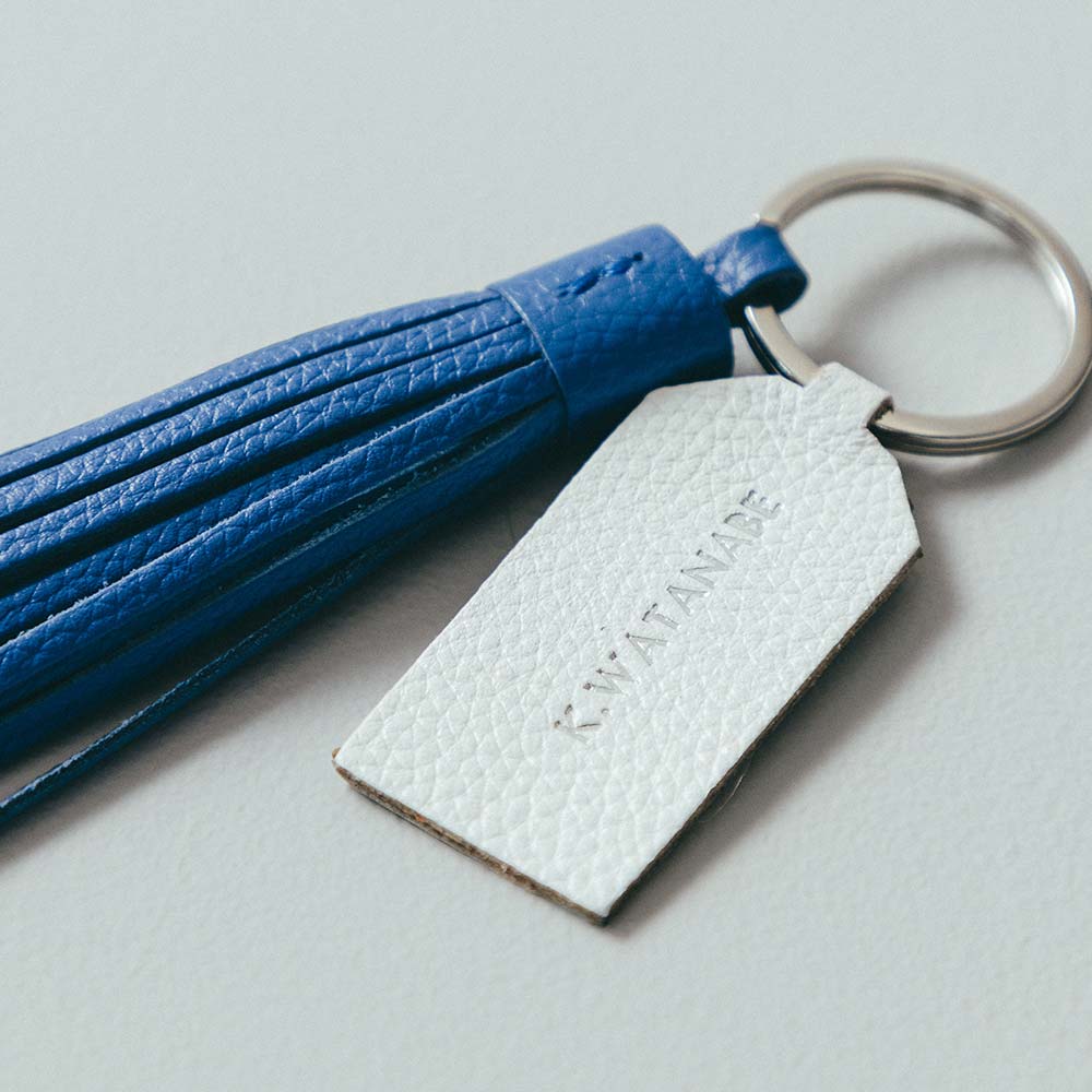 レザータッセルチャーム - 名入れはタグの表面に入ります。無料の刻印オプションで、世界で一つだけの特別なアイテムに。