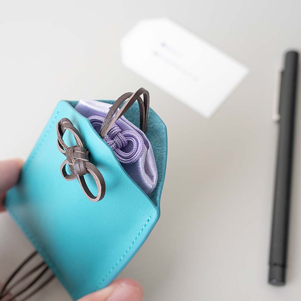 革のお守りケース（ネックレス） - 上部のストラップを緩めると、お守りが出し入れできます。大切なお守りを汚さないように、全体を包み込む形状になっています。