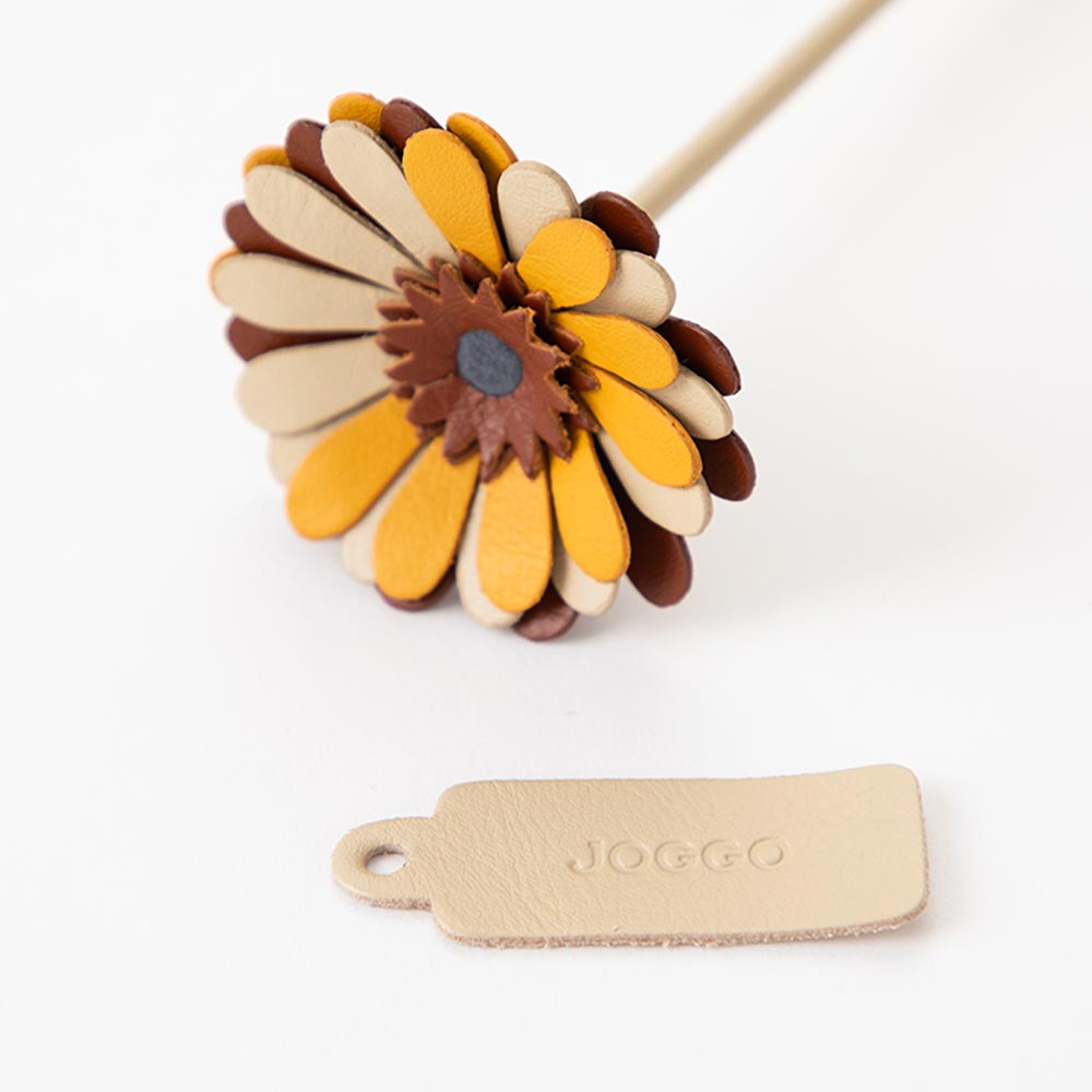 革の一輪花（ガーベラ） - ＪＯＧＧＯのロゴが刻印されたブランドタグが付いています。タグの色でアクセントを加えても素敵です。タグは取り外しも可能です。